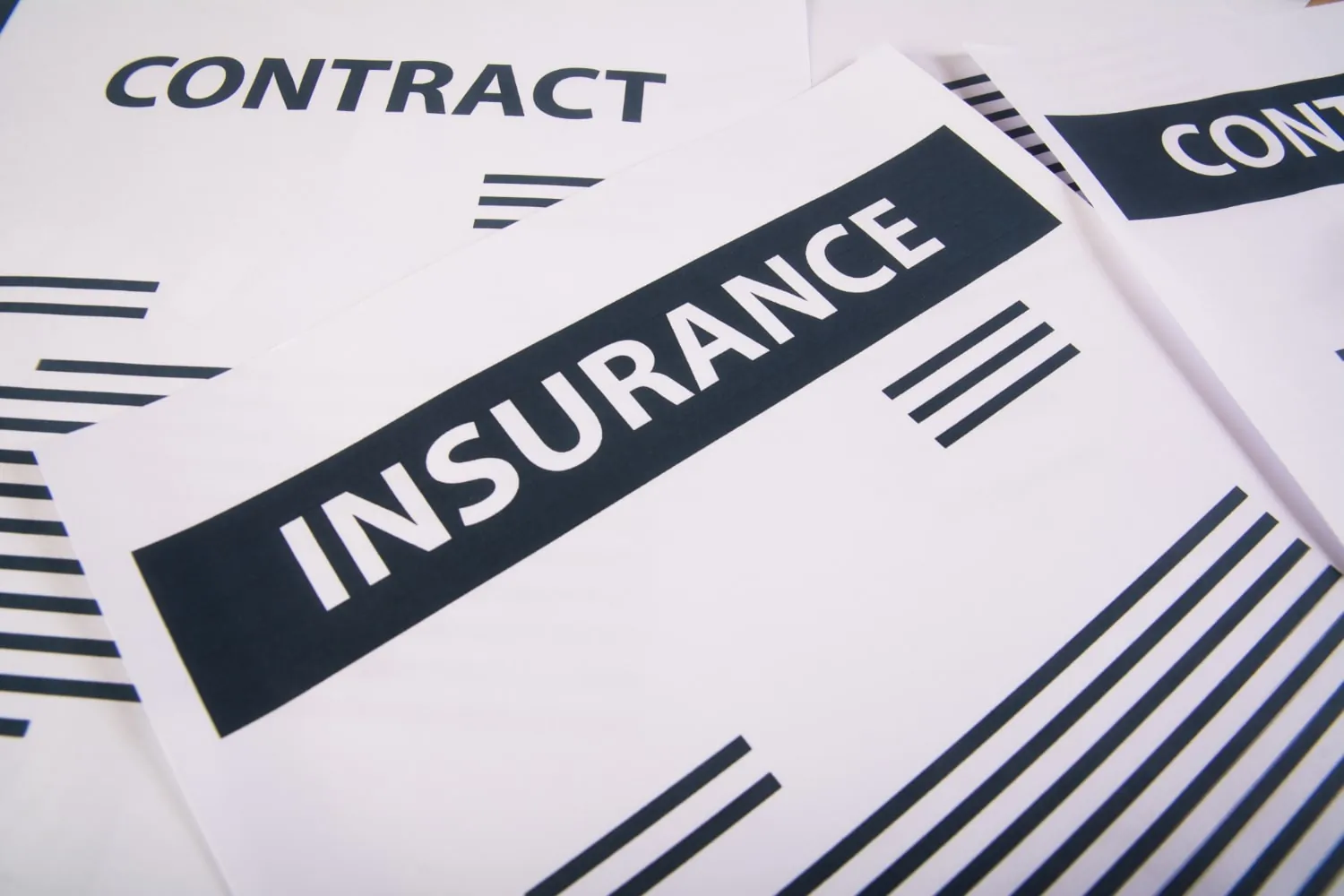 Insurance contract next to a damaged roof, signifying the acceptance of a property damage claim