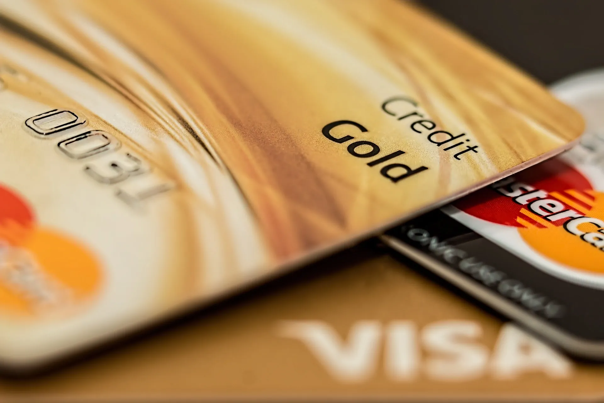 Close-up of a stack of credit cards, highlighting a gold credit card, related to financial obligations and credit card debt.