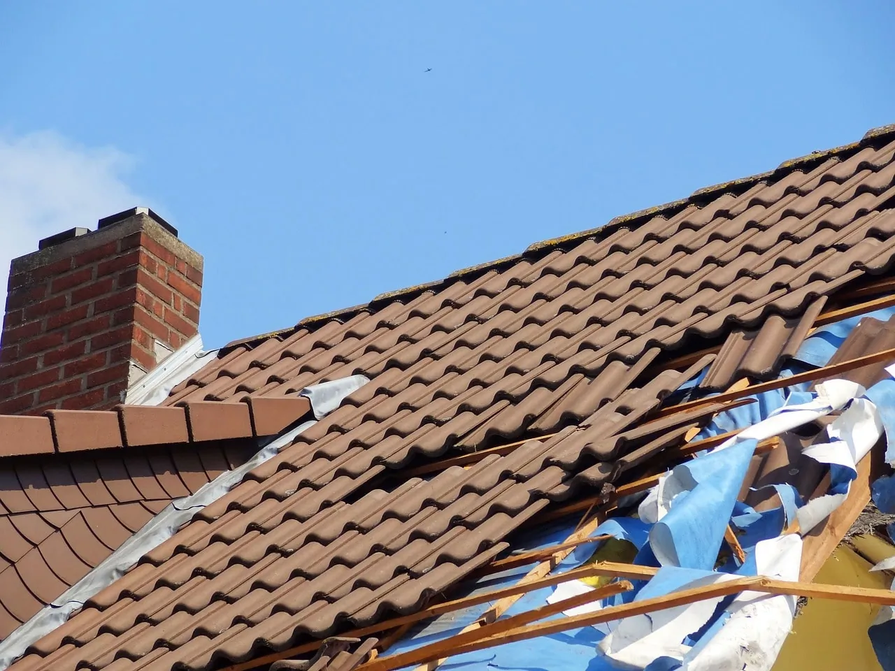 Damaged roof with an insurance contract, illustrating an insurance company's liability acceptance.