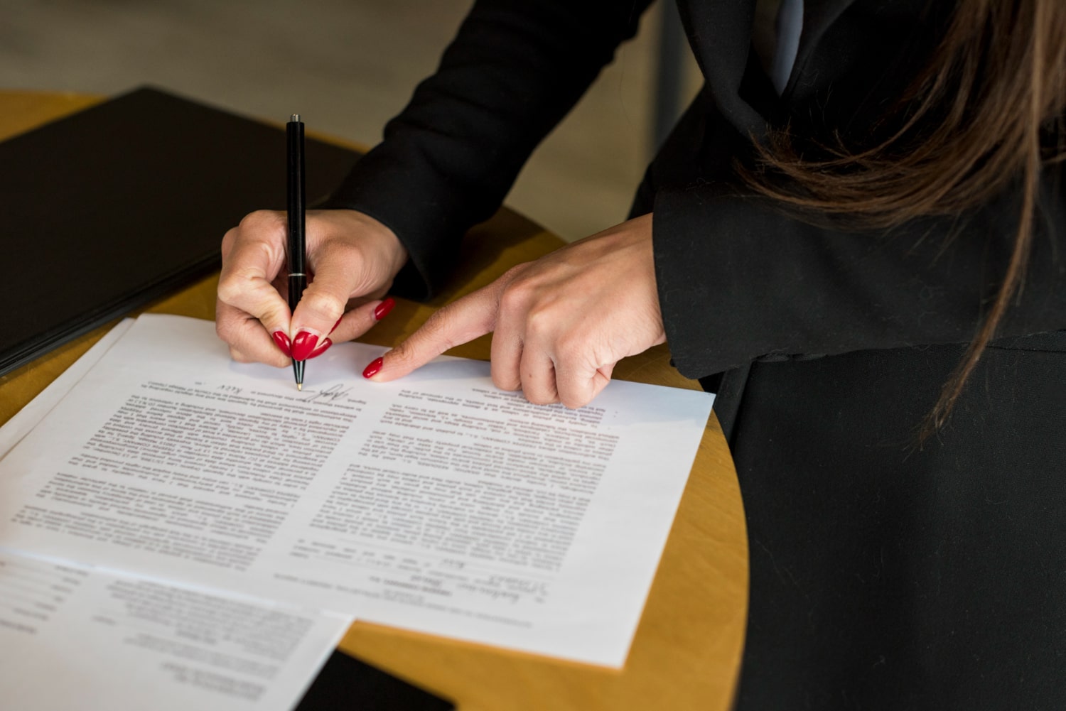 mediation document while holding a pen, indicative of reviewing terms during personal injury mediation