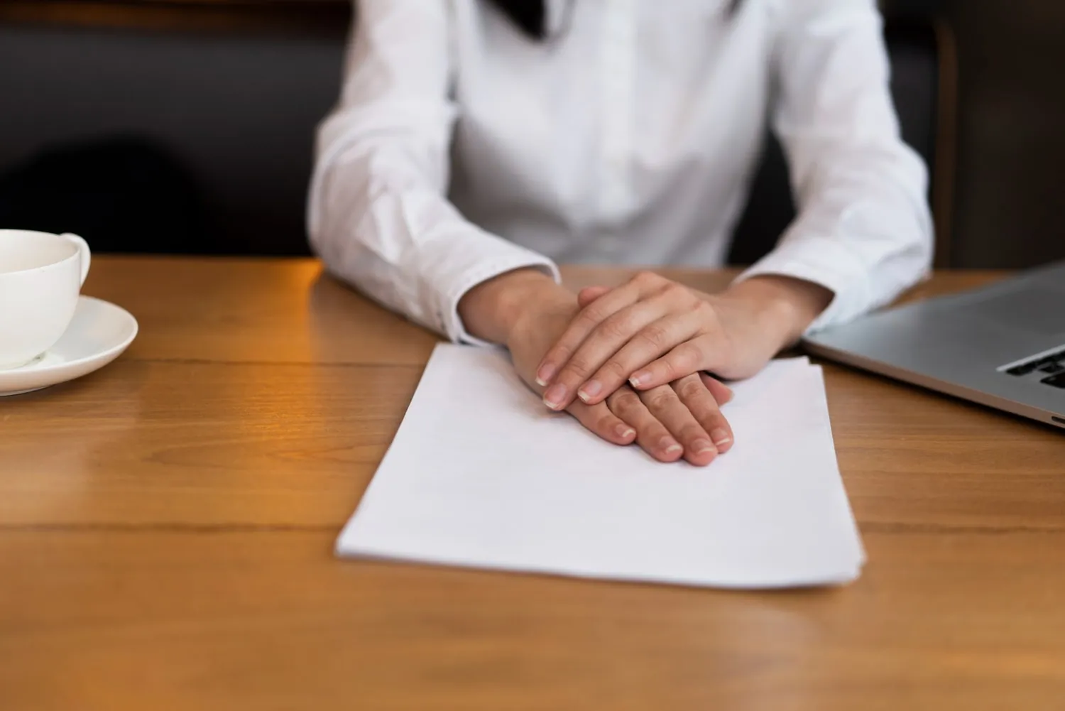 waiting with hands clasped over a blank sheet of paper, ready for a personal injury mediation session