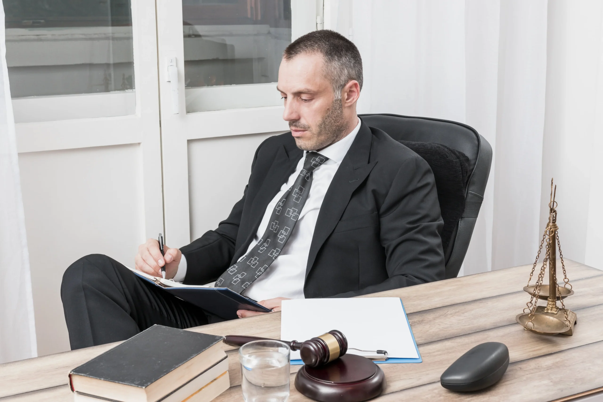 A male lawyer scheduling appointments at his office desk.