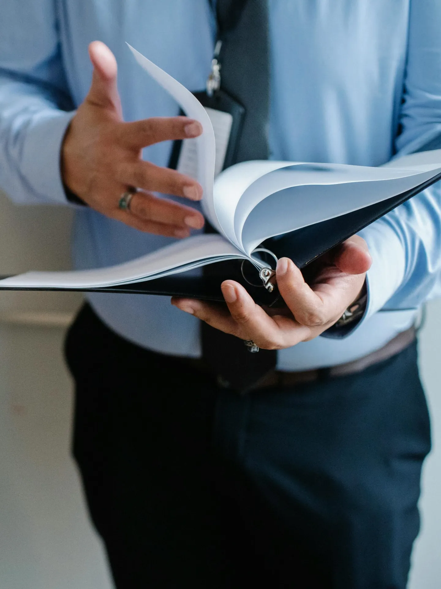 A professional flipping through documents, representing the legal complexities involved in wrongful death settlements.