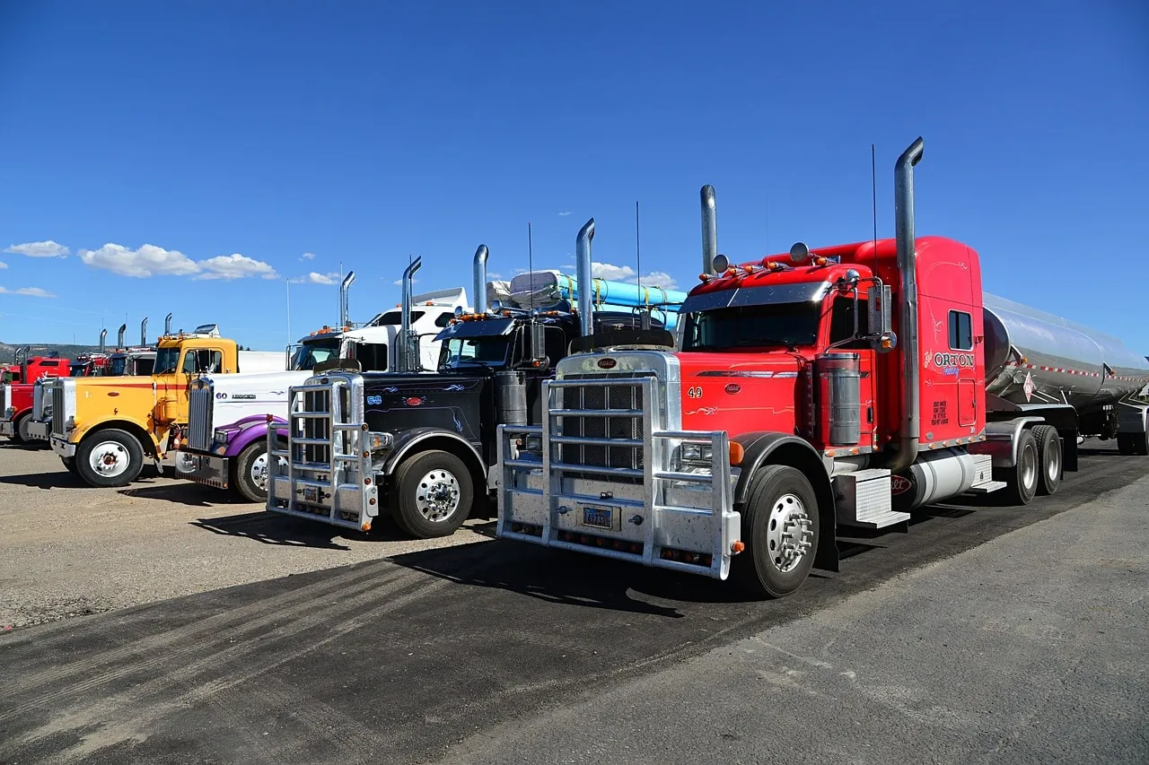 A lineup of brightly colored semi-trucks parked in a row at a truck stop