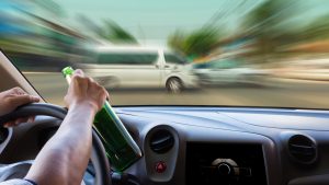 View from inside a car showing a driver holding a bottle and an oncoming van with motion blur, suggesting an imminent collision.
