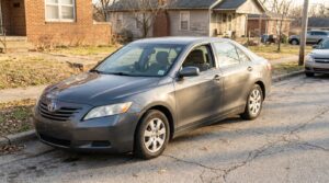 Toyota Camry sedan parked on residential street near brick houses